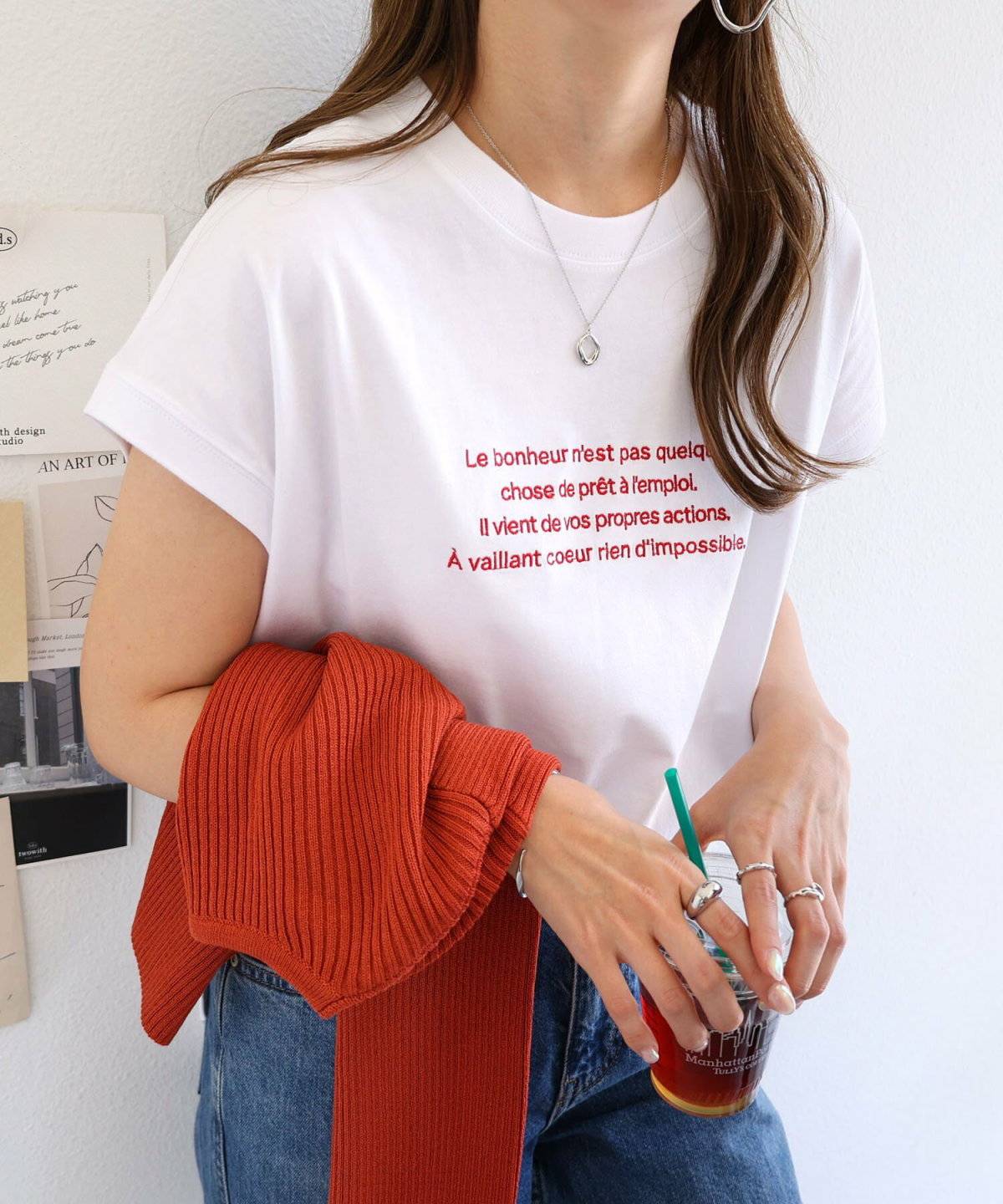 白Tシャツに白カーディガンを羽織ってデニムを合わせた女性