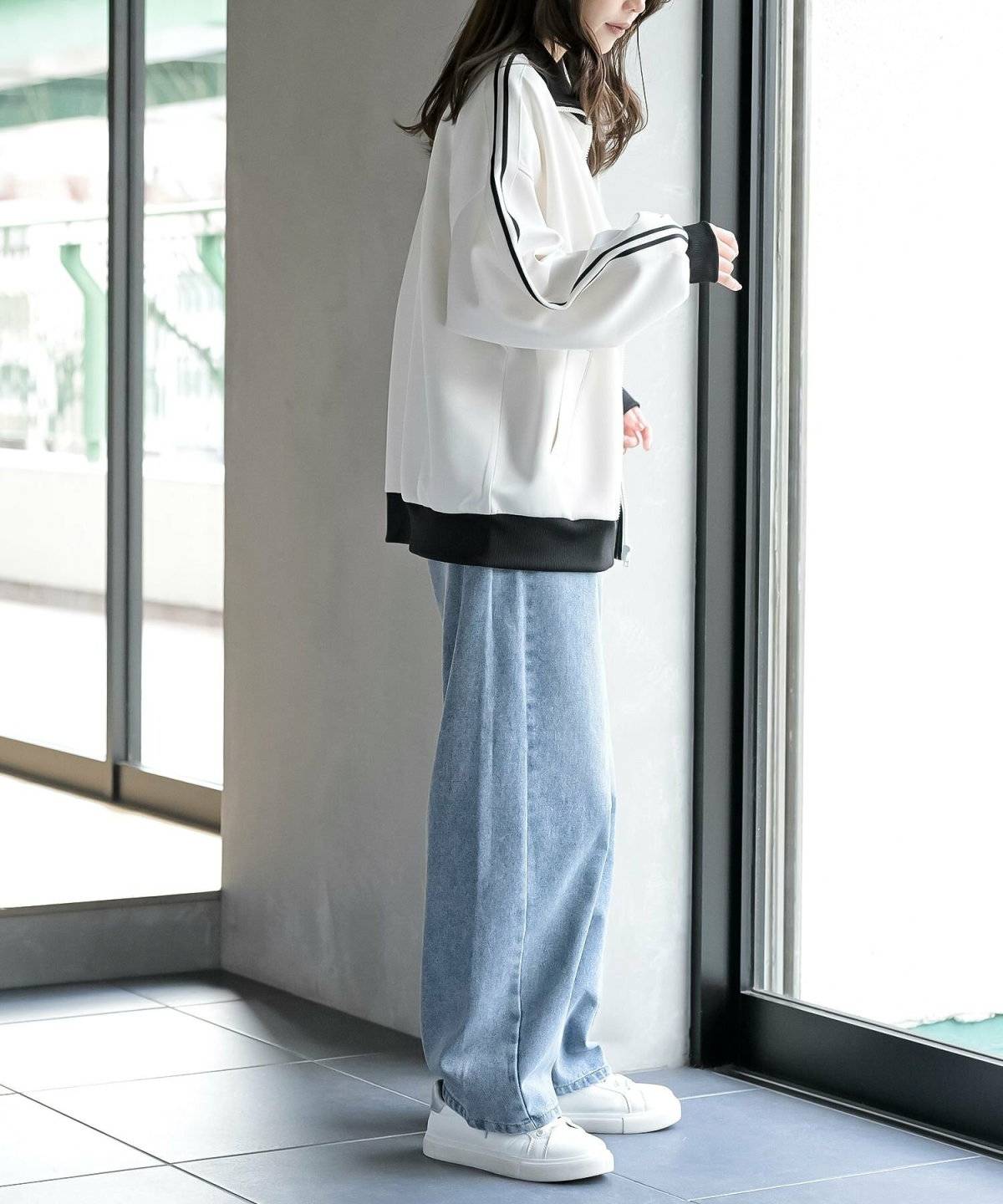 白トップスにデニムを合わせた女性