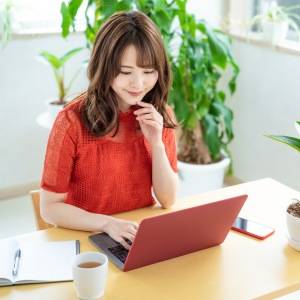  PCを見ながらビジネスを考える女性 