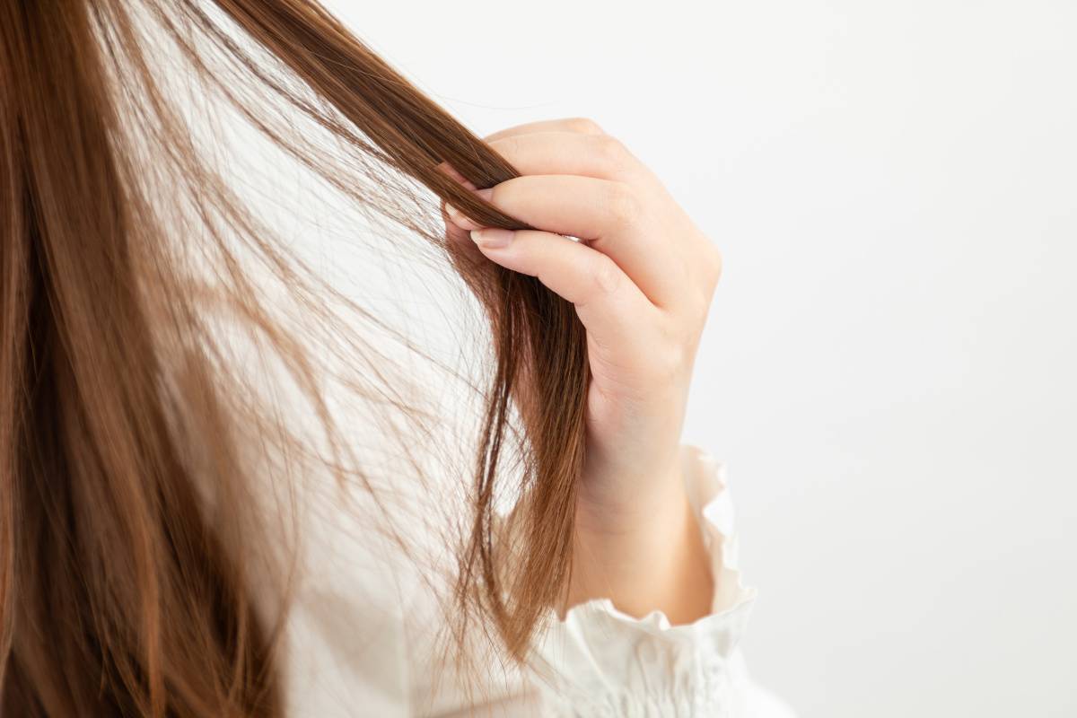 髪の毛を触る女性の手元
