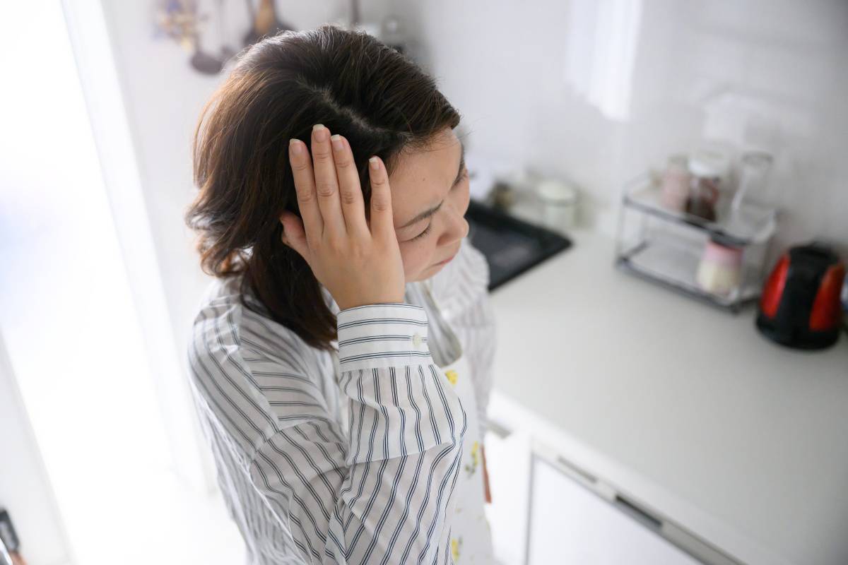 頭を押さえる女性
