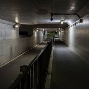  手すりで仕切られた、コンクリート造りの地下通路 