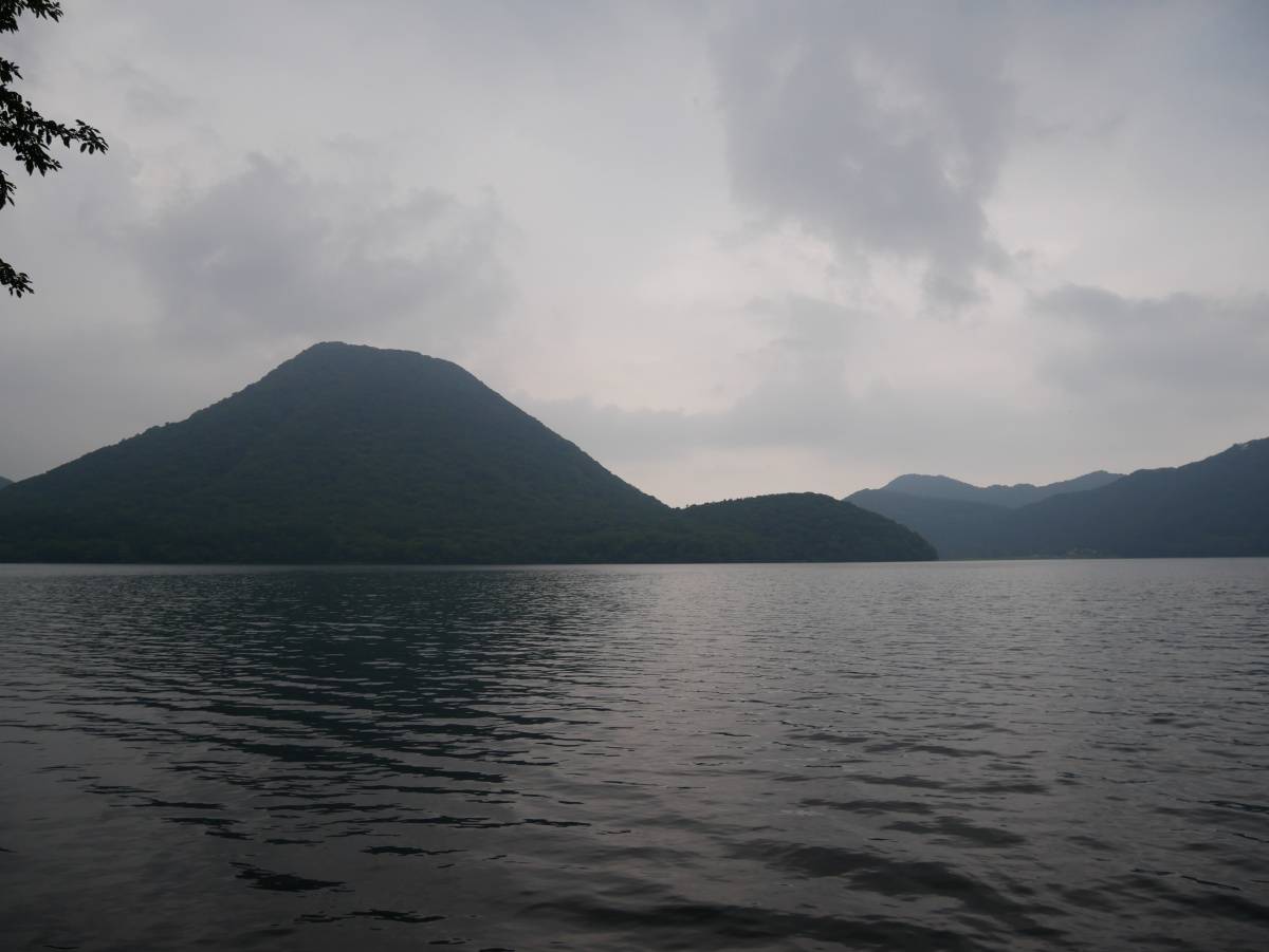 湖の向こうに山並みが広がる、静かな水辺の風景