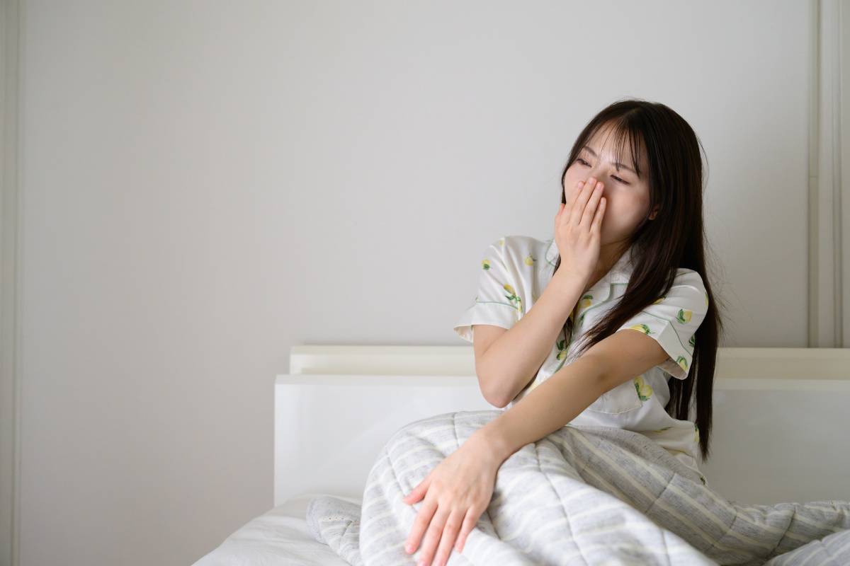 ベッドであくびをする女性